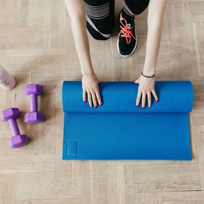 Yoga mat rolled out on a dark wooden floor.